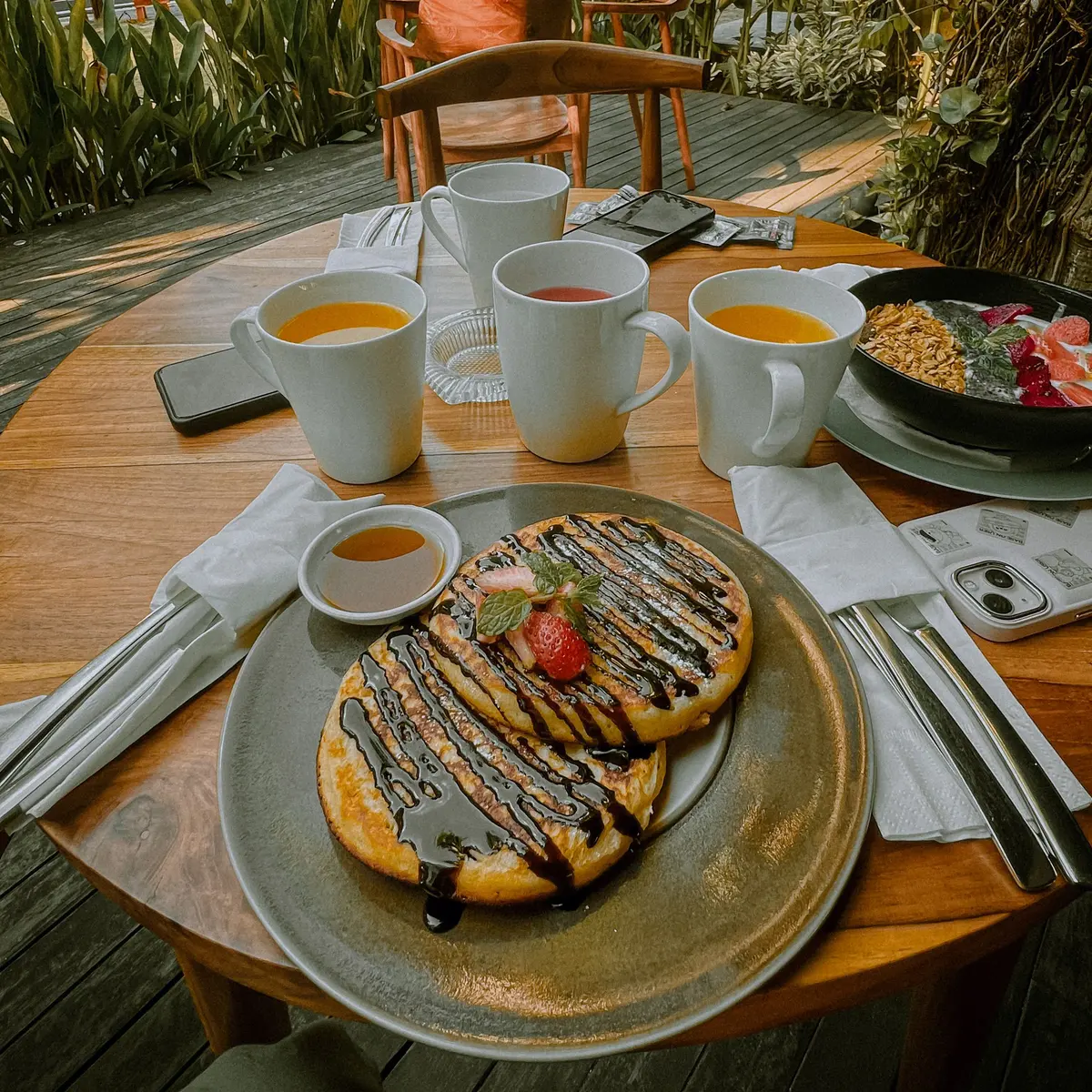 Breakfast table with pancakes, tea and juice