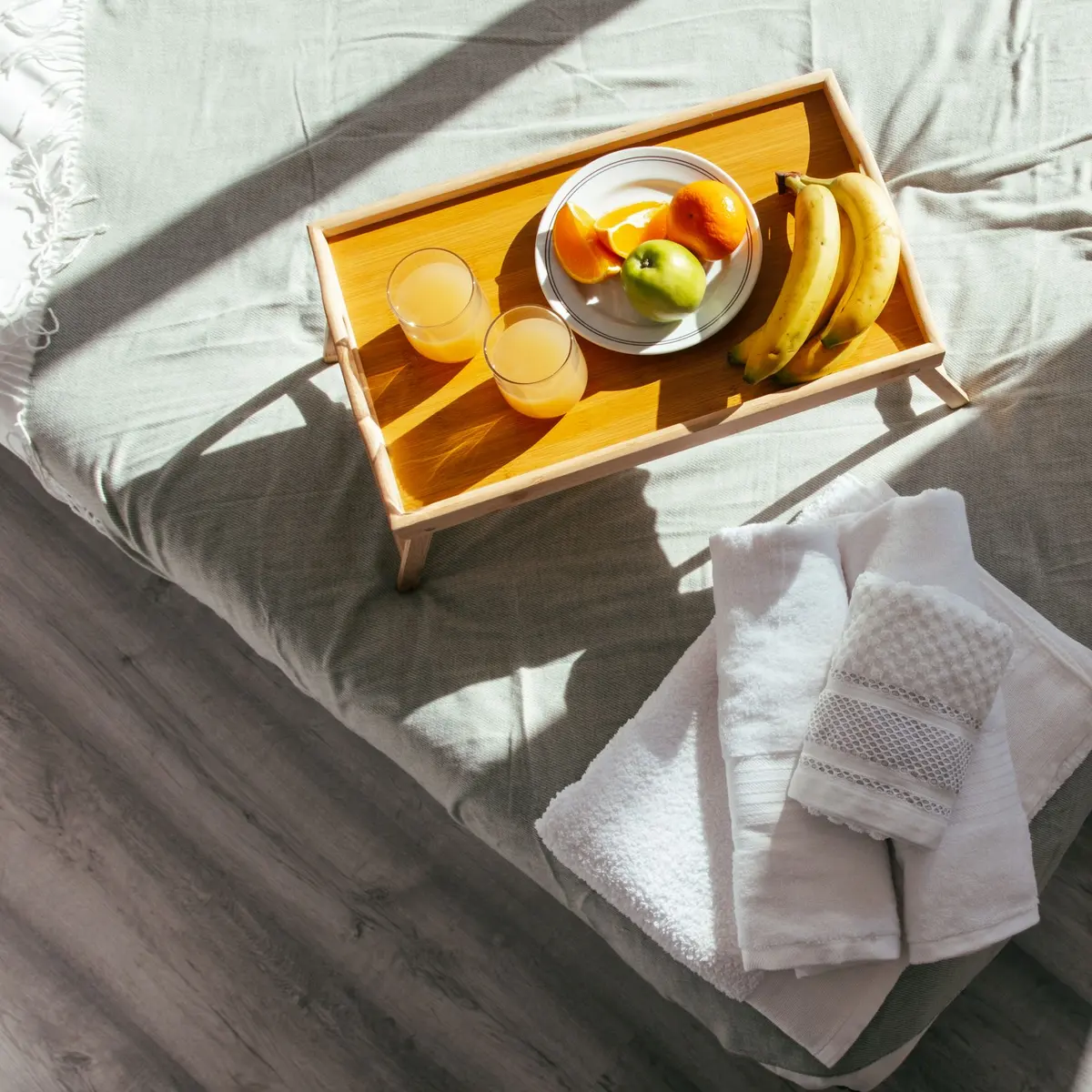 Tray with fruit and juice on a bed